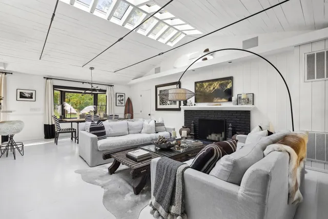 a living room with furniture fireplace and a large window