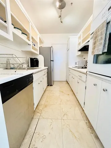 a large white kitchen with cabinets