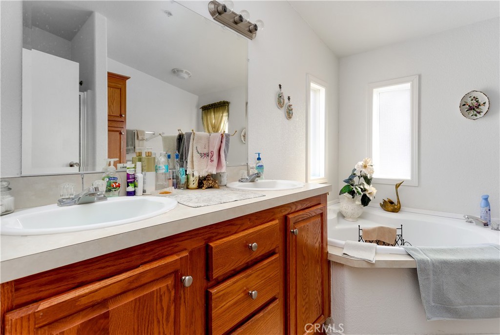 29520 Piani Road Pearblossom, CA 93553 - Photo 27 of 34 a spacious bathroom with a granite countertop sink and a large mirror