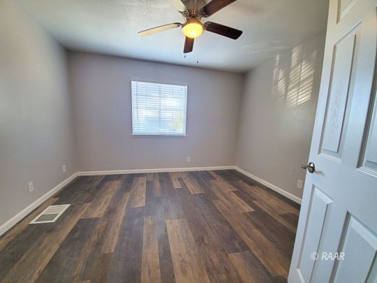 128 South Lilac Street Ridgecrest, CA 93555 - Photo 15 of 24 wooden floor in an empty room with a window