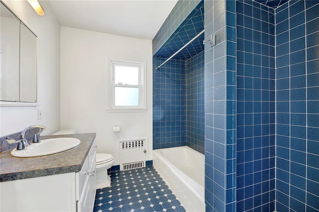 2991 Quentin Road Brooklyn, NY 11229 - Photo 21 of 30 a bathroom with a granite countertop sink a toilet a mirror and shower