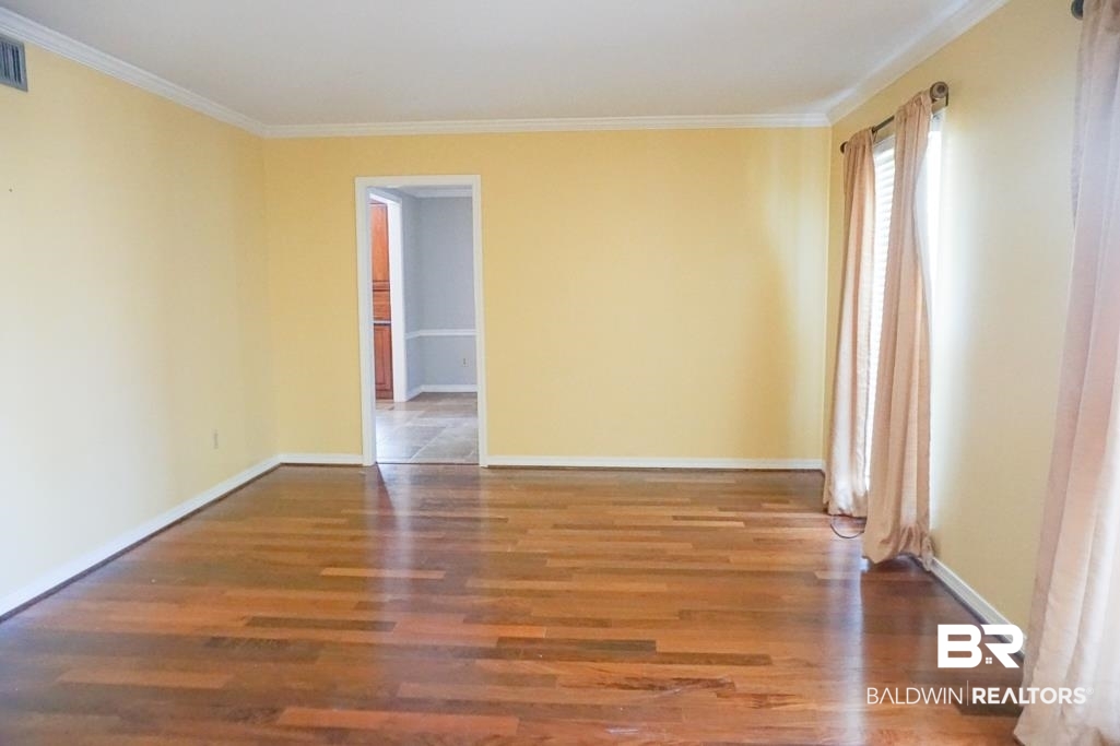 255 Suffolk Road Mobile, AL 36608 - Photo 13 of 29 Empty room with wood finished floors and ornamental molding
