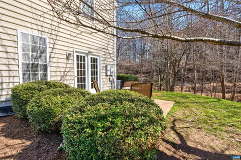 a view of a backyard with table and chairs with wooden fence and plants
