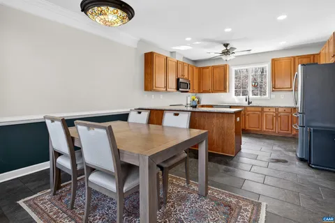 a kitchen with granite countertop a sink a stove a dining table and chairs