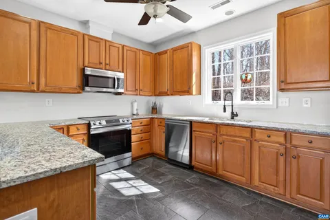 a kitchen with stainless steel appliances granite countertop a sink stove and microwave