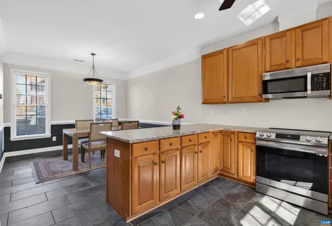 a kitchen with granite countertop a stove a sink dishwasher and cabinets with wooden floor