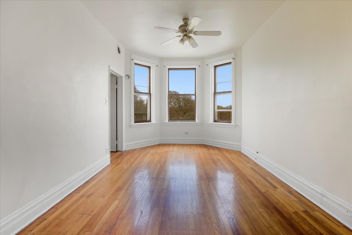 3133 West Augusta Boulevard, Unit 3E Chicago, IL 60622 - Photo 2 of 10 a view of an empty room with window and wooden floor