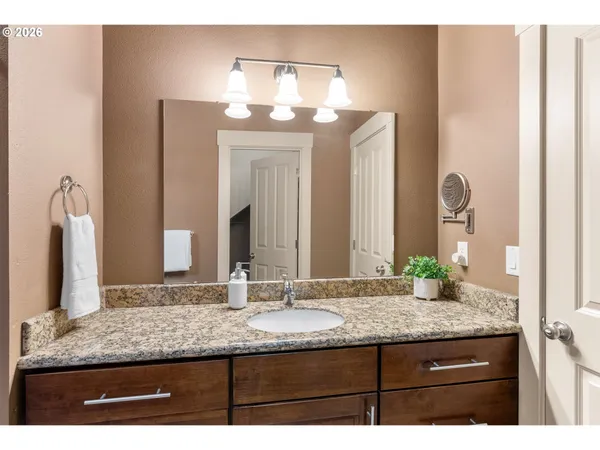 a bathroom with a granite countertop sink and a mirror