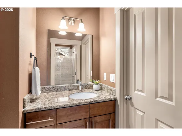 a bathroom with a granite countertop sink and a mirror