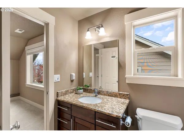 a bathroom with a granite countertop sink a mirror and a vanity