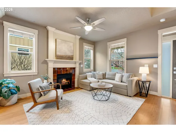 a living room with furniture a fireplace and a large window