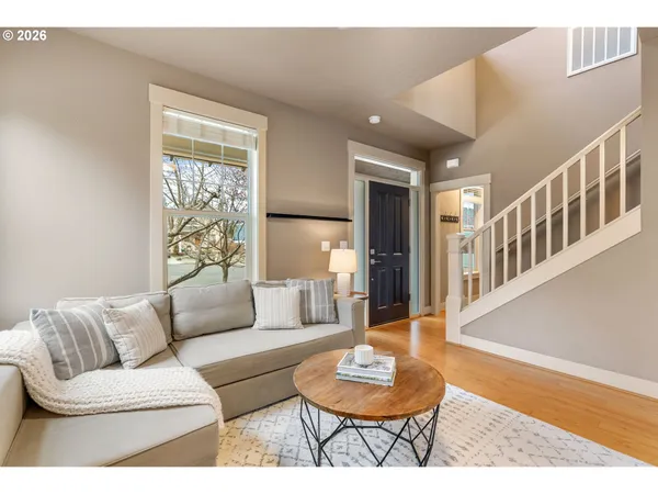 a living room with furniture and a wooden floor