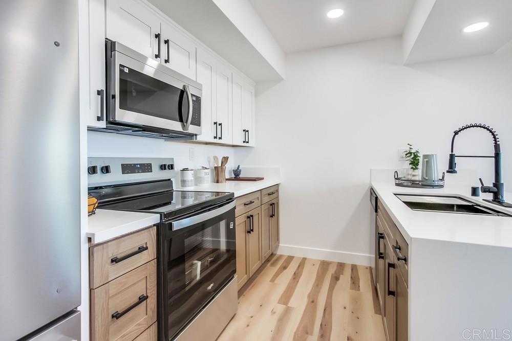 3606 Vista Rey, Unit 37 Oceanside, CA 92057 - Photo 10 of 45 a kitchen with stainless steel appliances a stove microwave and sink
