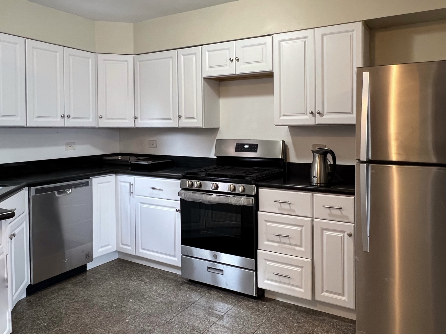 2131 South Archer Avenue, Unit 306 Chicago, IL 60616 - Photo 2 of 15 a kitchen with white cabinets and black appliances