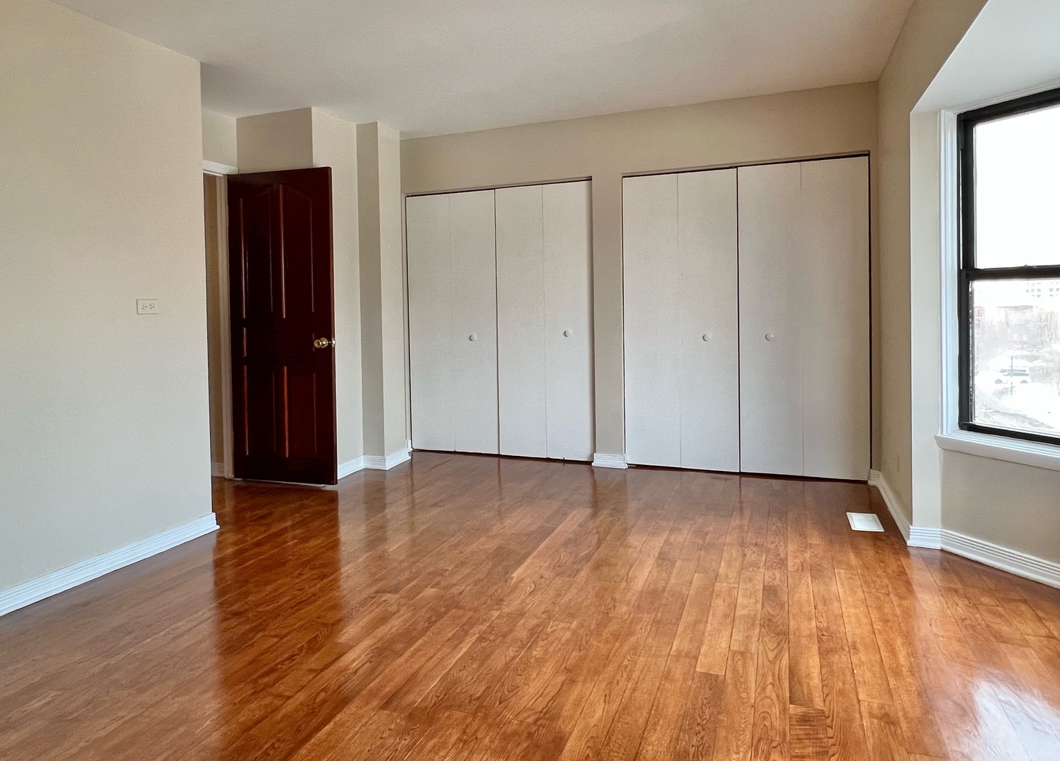2131 South Archer Avenue, Unit 306 Chicago, IL 60616 - Photo 7 of 15 a view of an empty room with wooden floor and a window