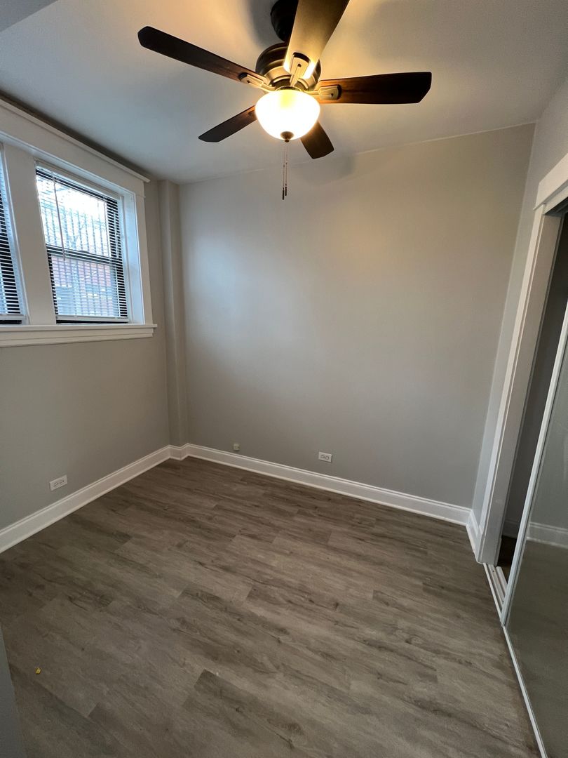 Undisclosed Address Chicago, IL 60613 - Photo 12 of 12 a view of an empty room with wooden floor and a window