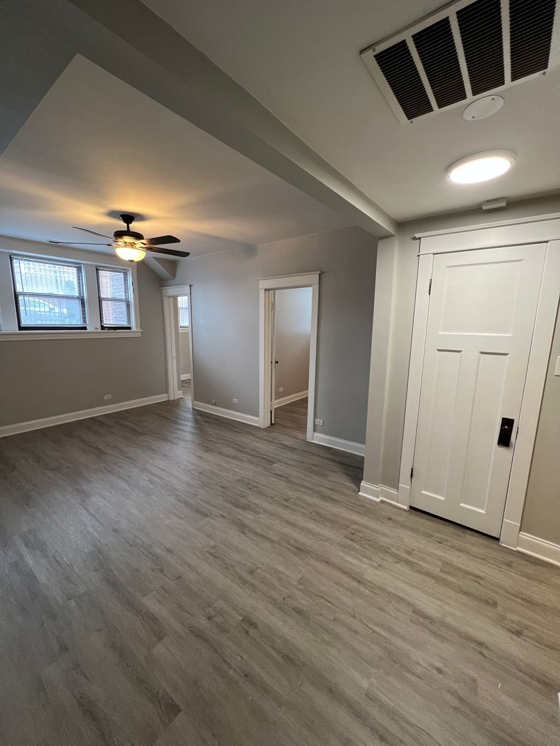 Undisclosed Address Chicago, IL 60613 - Photo 2 of 12 an empty room with wooden floor and windows