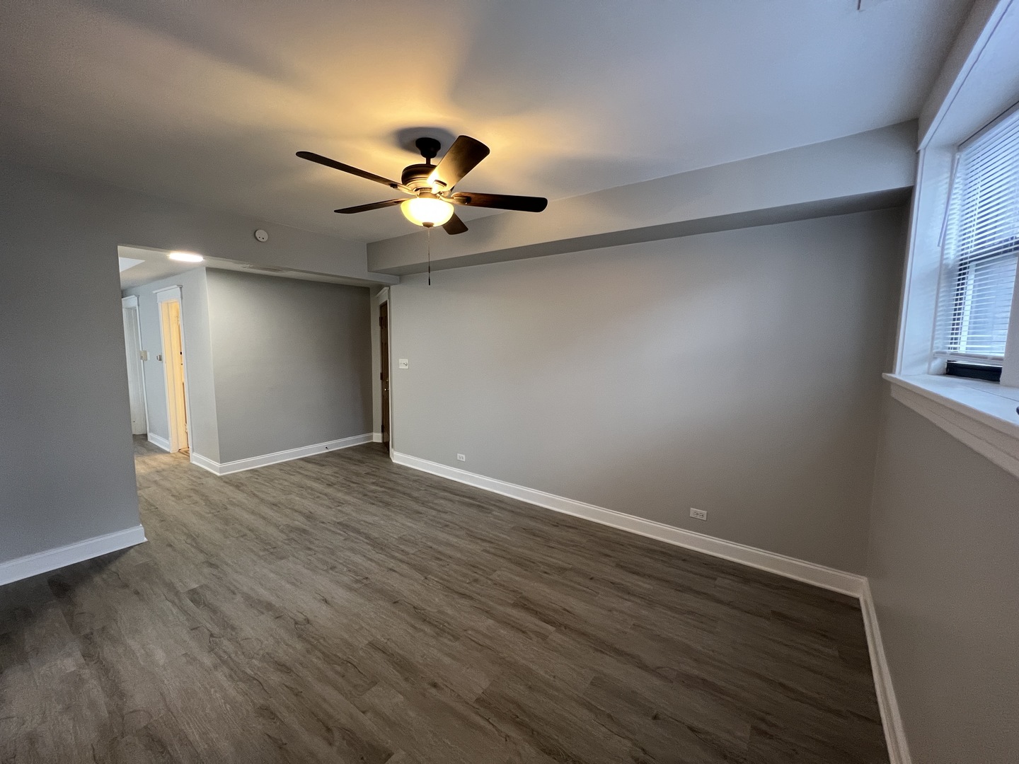 Undisclosed Address Chicago, IL 60613 - Photo 3 of 12 a view of an empty room with wooden floor and a window