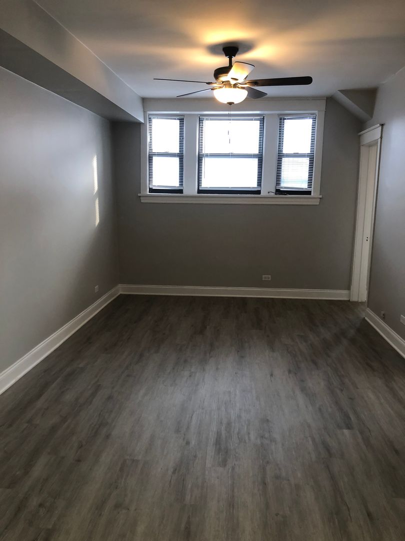 Undisclosed Address Chicago, IL 60613 - Photo 4 of 12 an empty room with wooden floor and windows