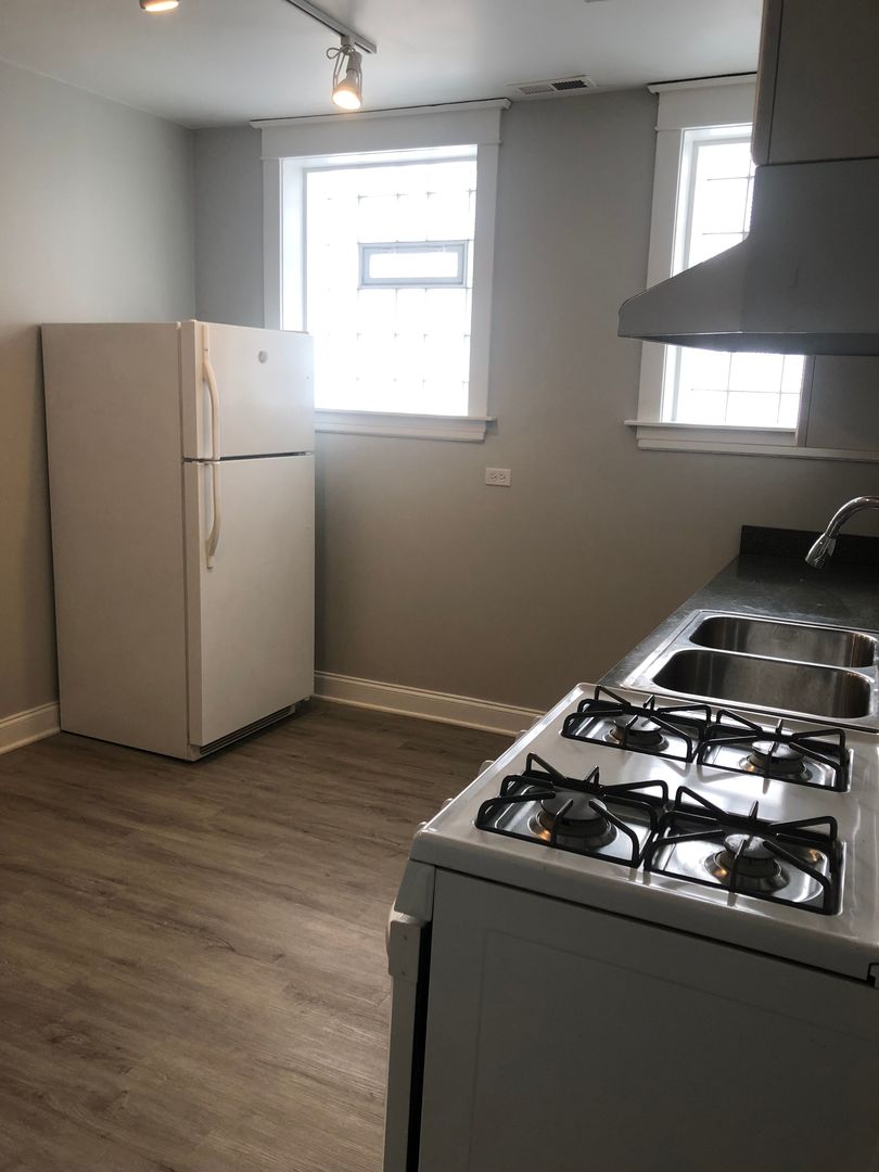 Undisclosed Address Chicago, IL 60613 - Photo 8 of 12 a kitchen with granite countertop a sink stove and refrigerator