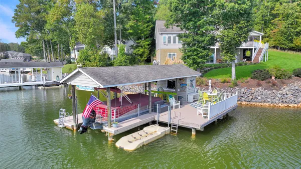 an aerial view of a house with swimming pool and a chairs