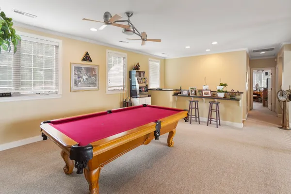 a kitchen with stainless steel appliances granite countertop a stove a refrigerator a sink a dining table and chairs with wooden floor