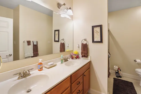 a kitchen with stainless steel appliances granite countertop wooden cabinets a sink a stove a refrigerator and island with wooden floor