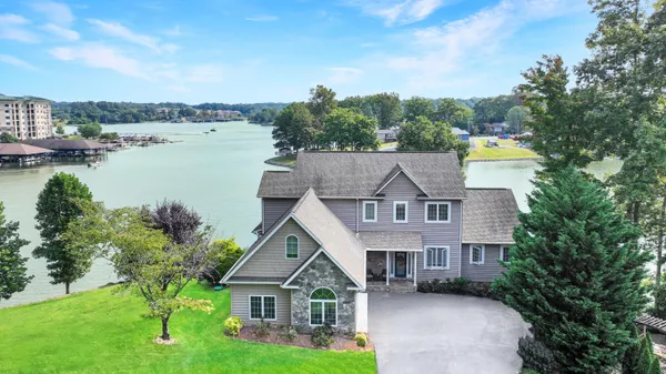 an aerial view of lake residential house with outdoor space and trees all around