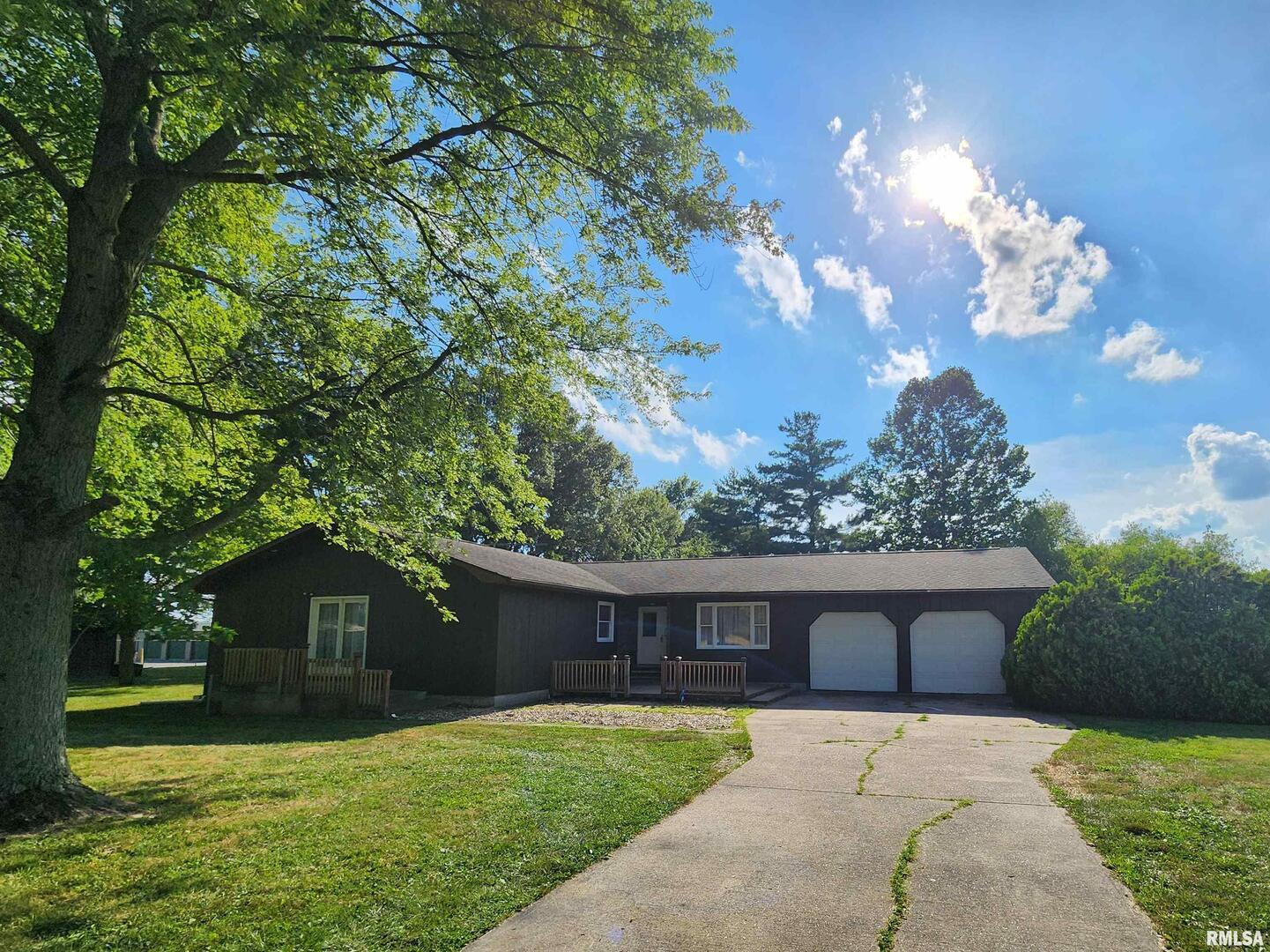 a front view of a house with a yard and trees