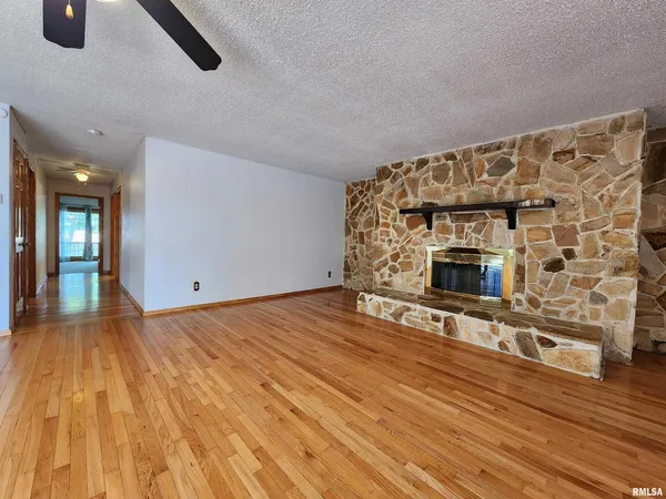 a view of empty room with wooden floor and fireplace