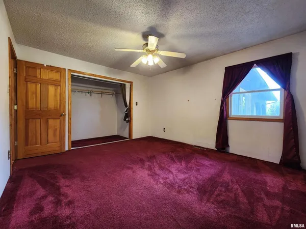 an empty room with windows and closet