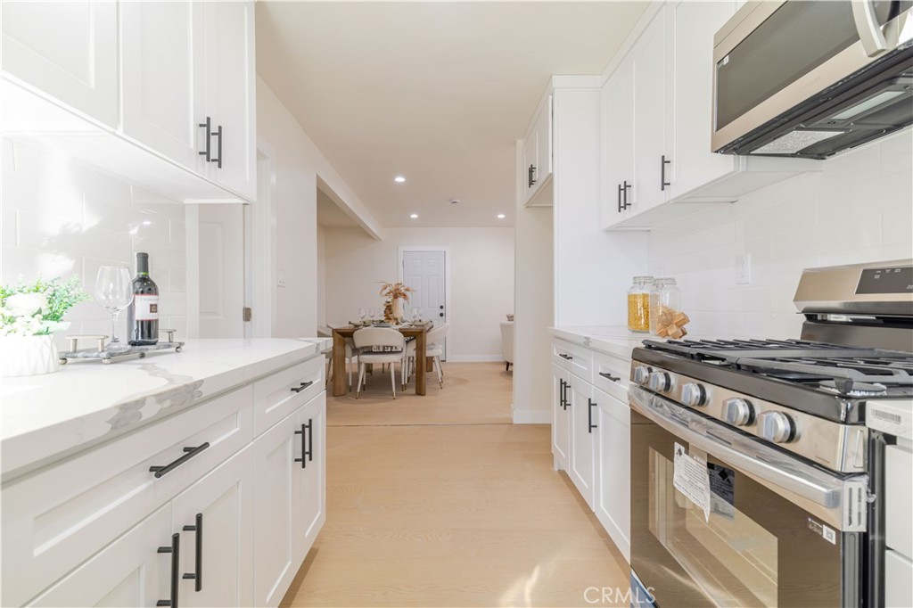 917 South Aprilia Avenue Compton, CA 90220 - Photo 12 of 24 a kitchen with a stove and white cabinets