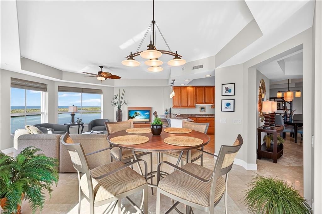 295 Grande Way, Unit 901 Naples, FL 34110 - Photo 11 of 50 a dining room with furniture a chandelier and wooden floor