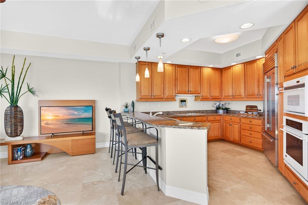 295 Grande Way, Unit 901 Naples, FL 34110 - Photo 13 of 50 a kitchen with stainless steel appliances granite countertop a stove a sink and a refrigerator