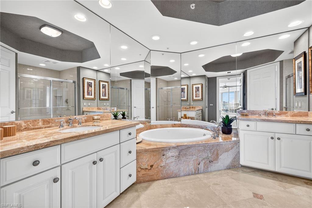 295 Grande Way, Unit 901 Naples, FL 34110 - Photo 20 of 50 a spacious bathroom with a granite countertop sink mirror and bathtub