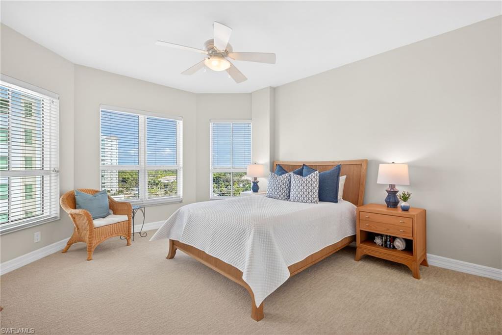 295 Grande Way, Unit 901 Naples, FL 34110 - Photo 21 of 50 a spacious bedroom with a bed and a chandelier