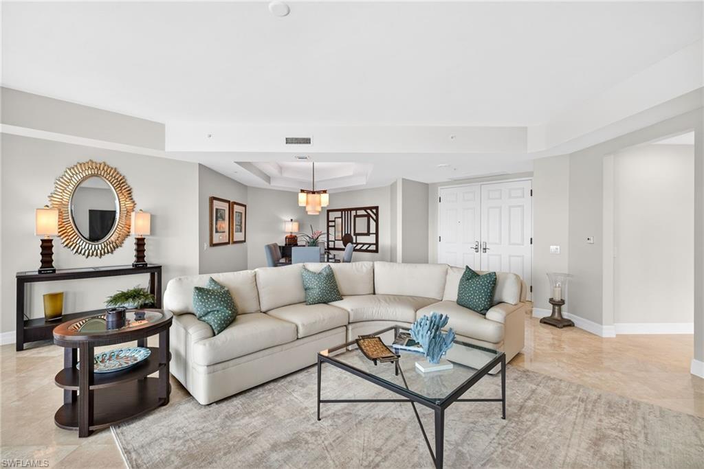 295 Grande Way, Unit 901 Naples, FL 34110 - Photo 6 of 50 a living room with furniture and a mirror