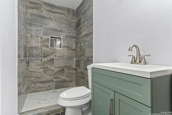 a bathroom with a sink toilet and a mirror