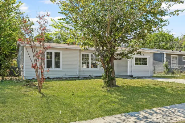 a view of a house with a large tree and a yard