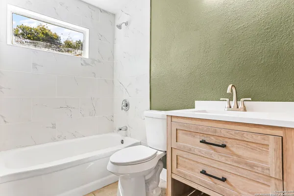 a bathroom with a sink a mirror a toilet and bathtub