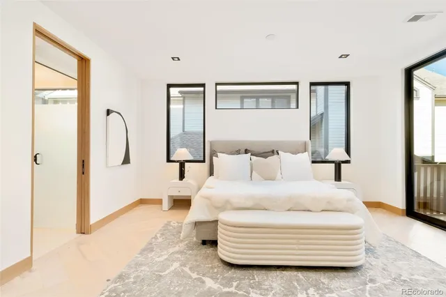 a spacious bedroom with a bed and glass windows