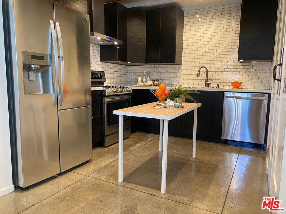 849 Pine Avenue Long Beach, CA 90813 - Photo 14 of 39 a kitchen with stainless steel appliances kitchen island granite countertop a sink refrigerator and cabinets