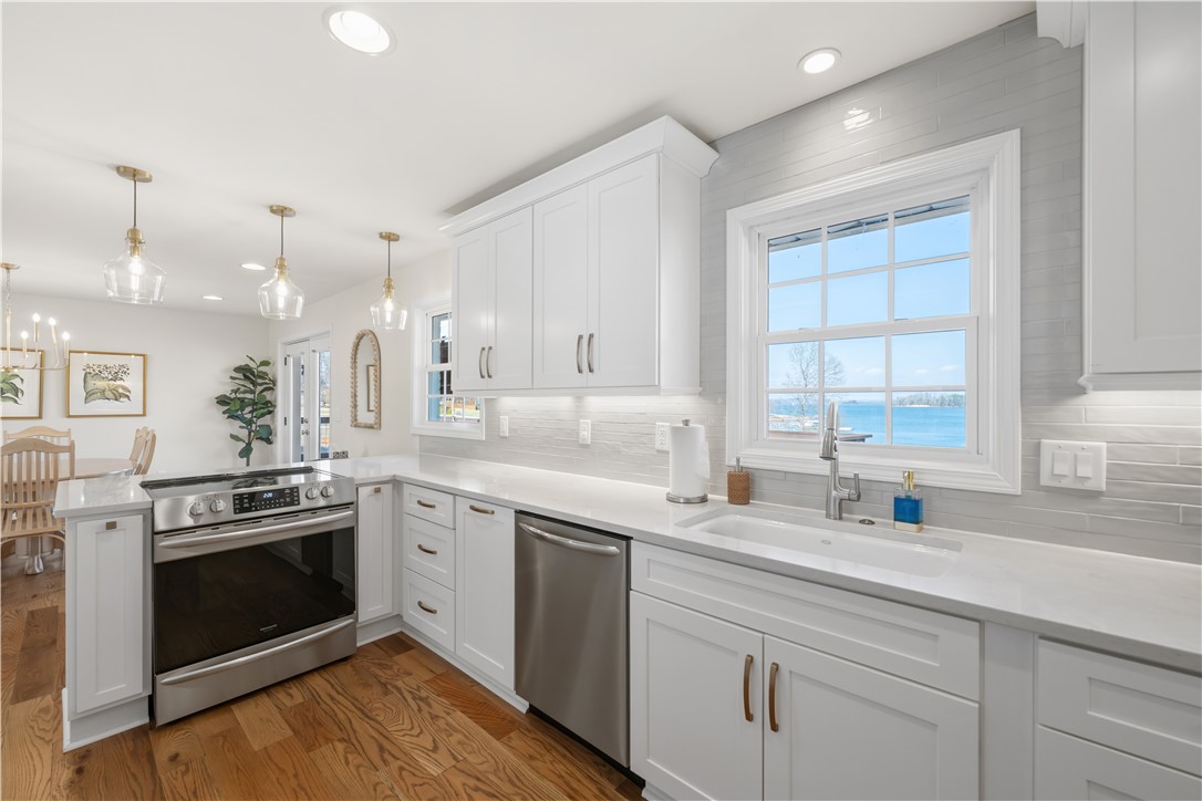 This bright kitchen offers modern design and serene water views through a large window.