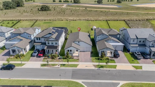 an aerial view of multiple houses with a lake