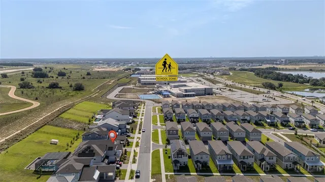 a view of a big house with a big yard and large trees