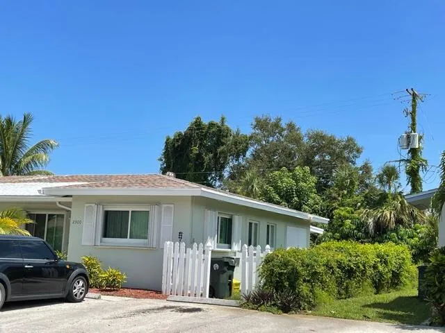 a front view of a house with a tree
