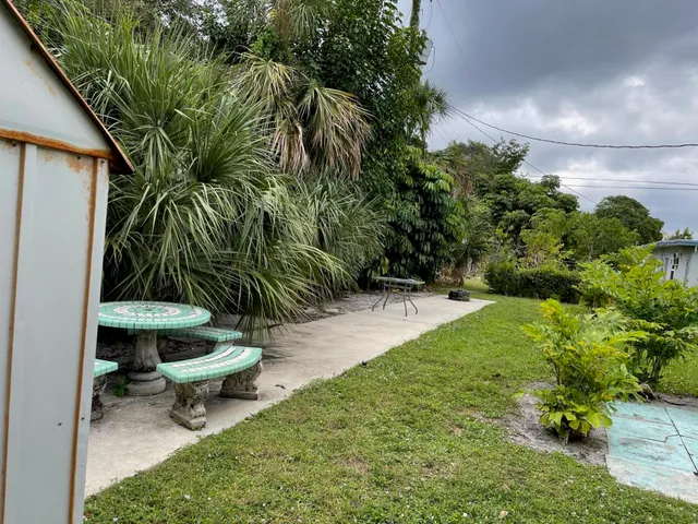 a view of a backyard with plants and a patio