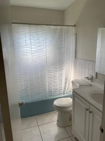a bathroom with a granite countertop toilet a sink and mirror