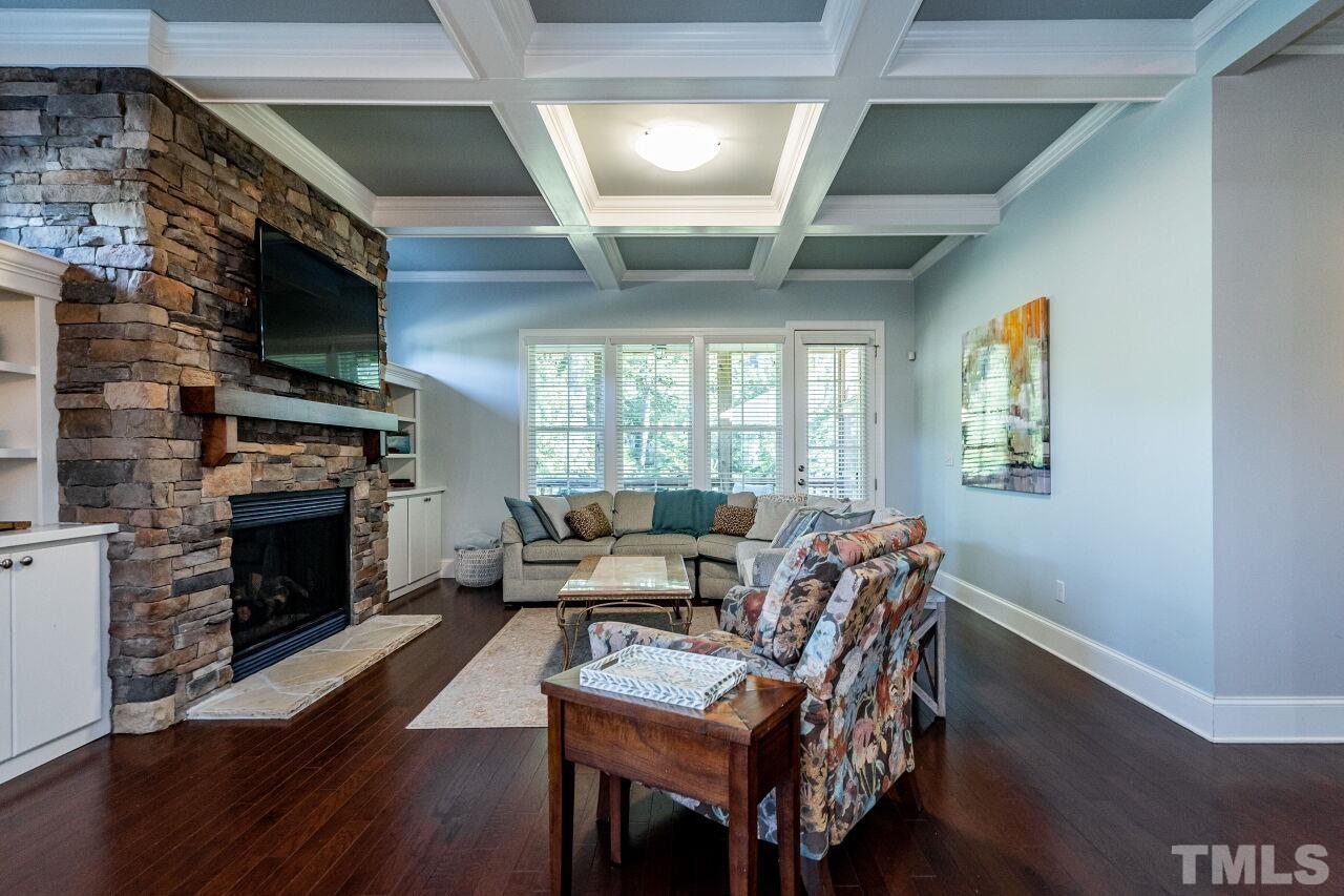 8035 Brandyapple Drive Raleigh, NC 27615 - Photo 11 of 30 Family Room with 10' coffered ceilings, gas log fireplace with stone surround, bookshelves/cases, hardwood floors and french door to screen porch.