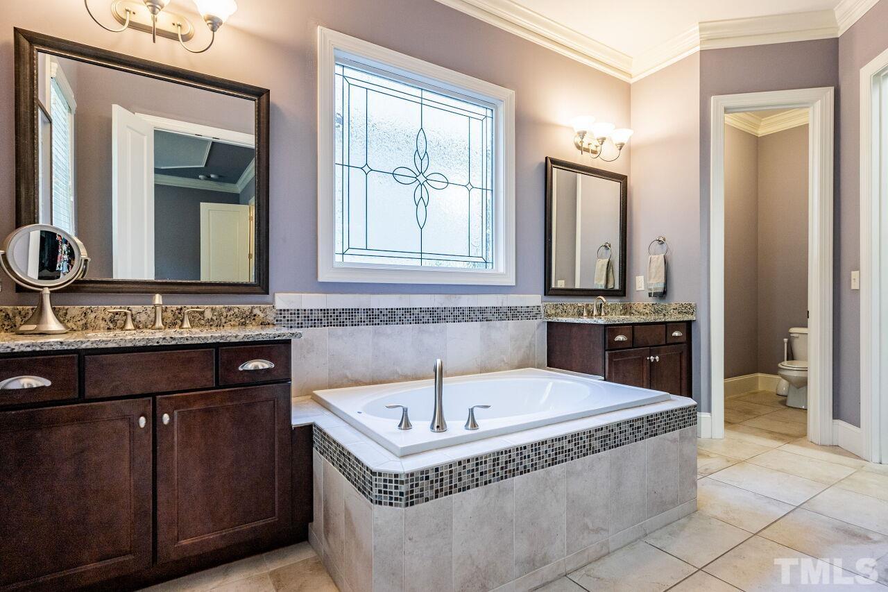 8035 Brandyapple Drive Raleigh, NC 27615 - Photo 16 of 30 Owners Bath with Garden Tub, separate shower, granite tops, dual vanities and tile floors.